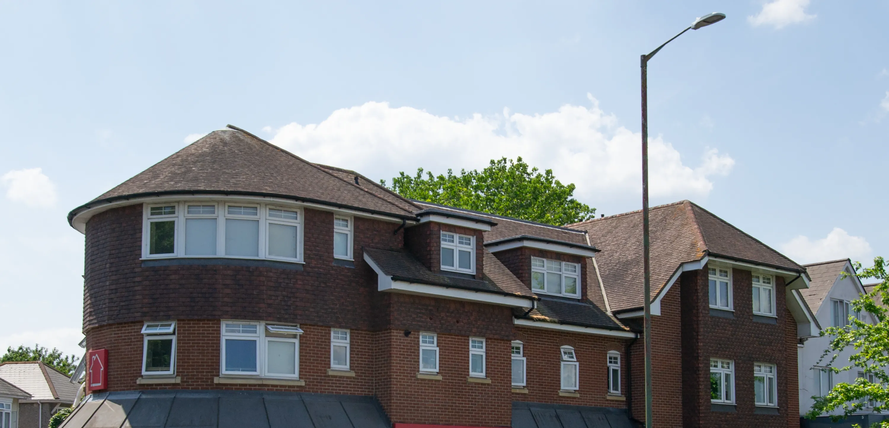 Castle Lane West, 122 to 124: a red brick block with a rounded corner turret