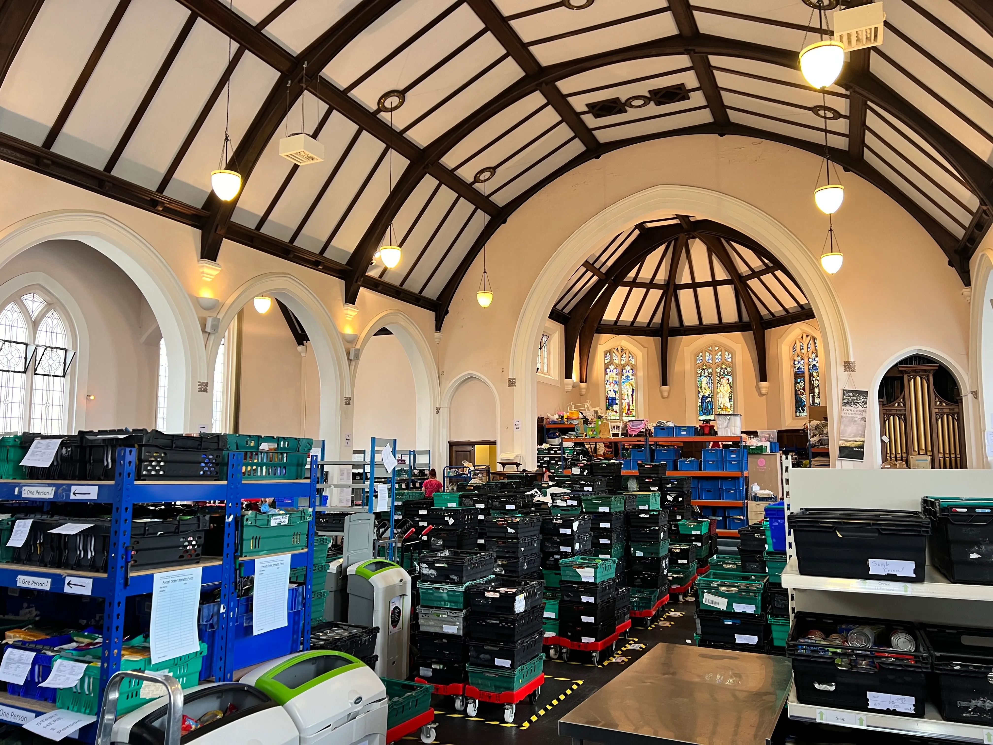 Inside St George's Methodist Church in Boscombe, crates and shelves of the foodbank under the arched roof